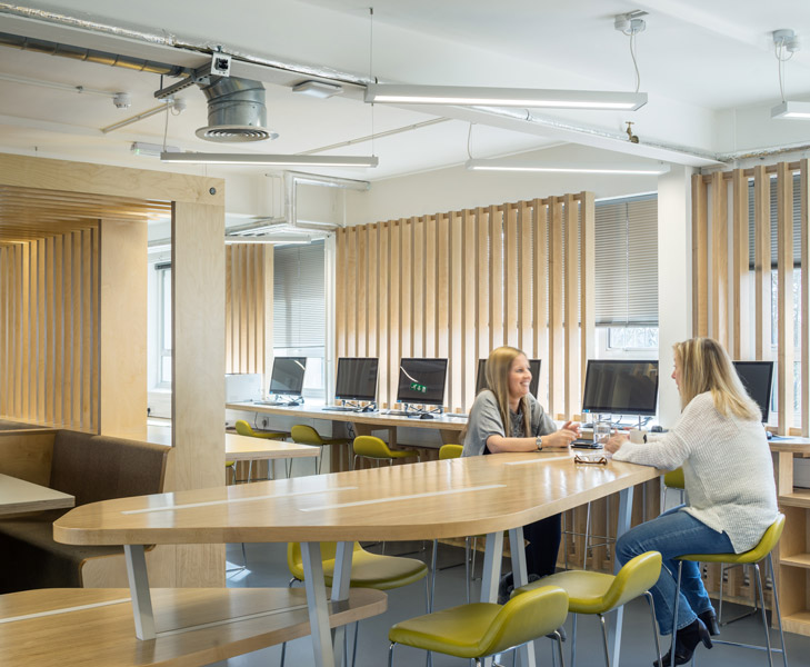 Interior photograph showing informal meeting at bespoke timber meeting table, 03 of 08